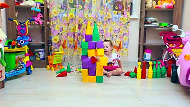 Little girl builds pyramid of blocks