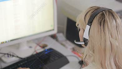 Close-up of business woman talking on headset in a call center
