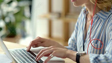Close up of female freelancer in headphones working online