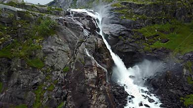 Waterfall in mountains of Norway in rainy weather from air view from drone