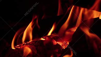 Hot coals in a campfire at night. Slow motion, closeups