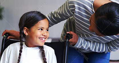 Mother interacting with girl in wheel chair