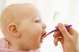 Mother feeding baby food to baby