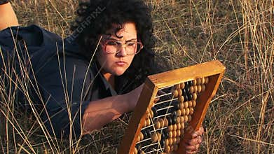 Odd Plus-Sized Woman In Black Playing With Abacus