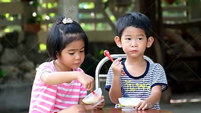 Two asian kids boy and girl eat ice cream