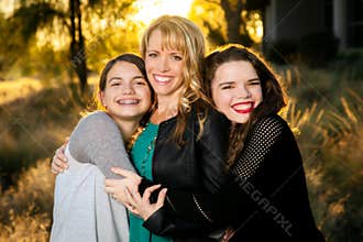 Two Teen Girls Hugging Their Mom