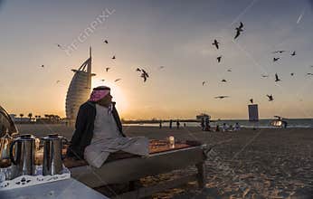 Old Arabic man sitting on the beach