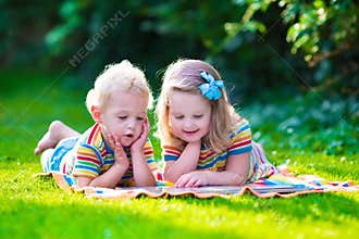 Two kids reading in summer garden