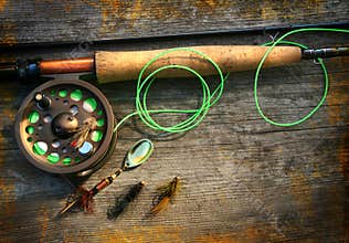 Fly fishing rod with polaroids pictures on wood