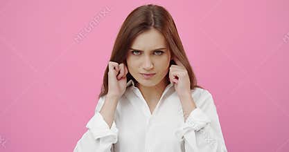 Woman plugging ears with hands while suffering from noise