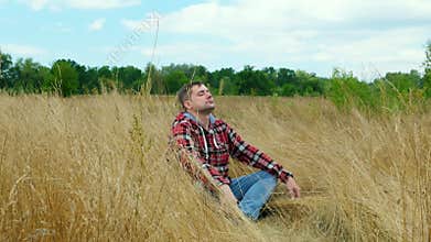 Young man sits in nature and meditates. Relaxation and rest.