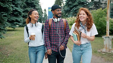 Slow motion of men and women walking outdoors on campus with books and coffee