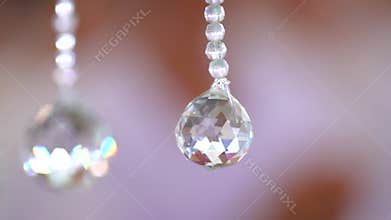 Close up Crystal ball from  Chandelier with blur Brown Pink background.