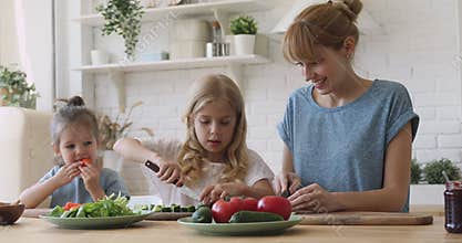 Pleasant nanny babysitter teaching kids girls cooking.