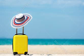 Summer travel and plan with yellow suitcase luggage in the sand beach. Travel in the holiday trips, airplane and blue sky backgrou