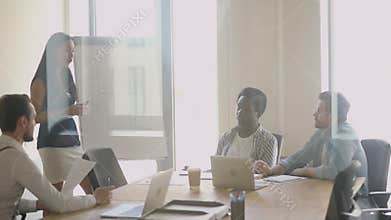 Motivated young focused diverse male employees listening to female presenter.