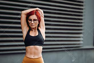 Fitness concept - attractive fit woman stretching arms
