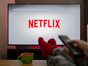 UK, March 2020: TV Television Netflix logo watching with feet up comfy