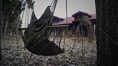 Haunted house with dark scary horror atmosphere. Old abandoned and spooky house. Horror atmosphere. Ramshackle swing