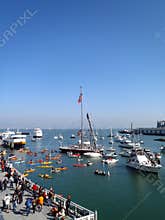 Promenade areafills with people, kayaks, boats