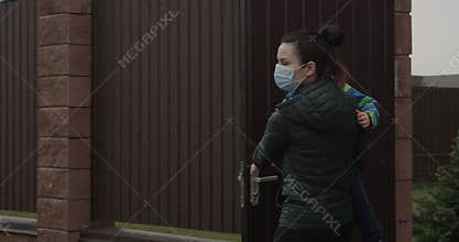 Parent with Child Closing Door wearing Face Masks a Concept of self-isolation and social distancing because of Pandemia of Coronav