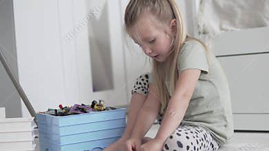 A little girl collects a designer from small parts in the game room