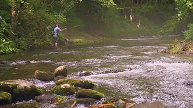 Fly fishing in a mountain stream, slow motion, tilt up