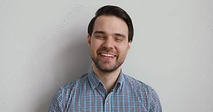 Young handsome emotional guy laughing at joke.