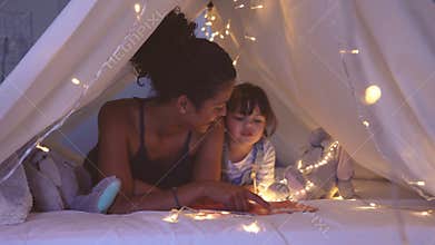 Loving ethnic mother telling a fairy tail to her little cute daughter