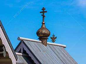 Orthodox cross on the roof of a religious building and a double-headed eagle - Russian coat of arms in the background