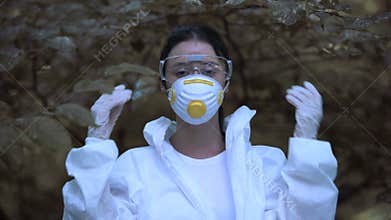Young woman taking off protective mask breathing free in forest, climate change
