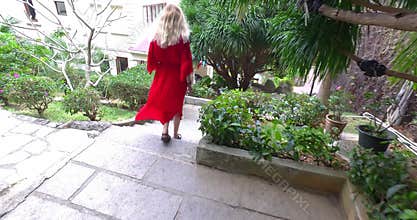 Blonde girl walking downstairs in in tropic hotel