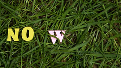 No waste letters appearing on green grass, protest against single-use plastic
