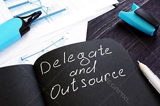 Delegate and Outsource written on a page. Delegation cincept