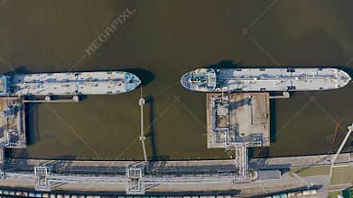 Aerial view port with railway infrastructure for the delivery of bulk cargo by sea, loading oil using a pump station in ship tanke