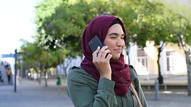 Young woman in hijab talking on phone
