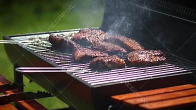 Tasty ribs cooking on barbecue grill for summer outdoor party