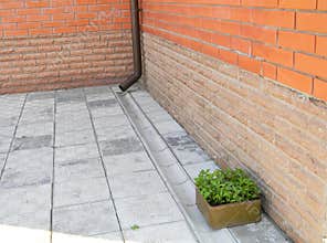 House rain gutter drain pipe with draine tranch on the pavement