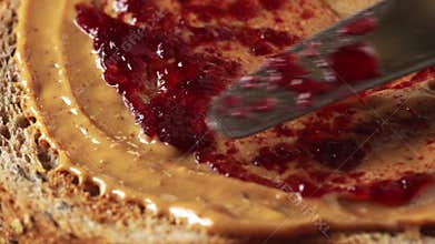 Spreading fruit jam on toast with peanut butter