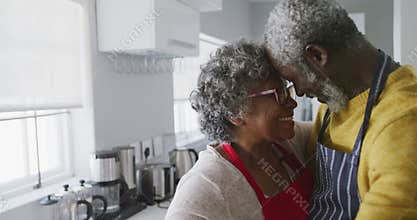 A senior african american couple spending time together at home dancing in the kitchen social distan