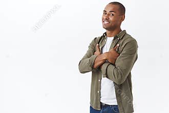 Portrait of african-american handsome man, looking pleased and assured, cross hands chest confident, promotion of client