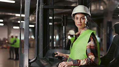 Portrait of Beautiful Warehouse Worker Woman Sitting in Forklift Looking at Camera