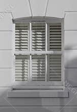 UK house exterior with wooden casement window and white bricks wall