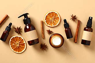 Set of fall natural skincare cosmetics with dried orange slices, cinnamon sticks, anise stars. Amber glass bottes packaging design