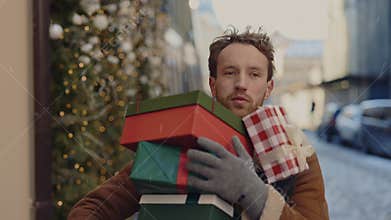Man is hurry up , running on the street holding many christmas gifts for his family and one falls. Caucasian man rushly