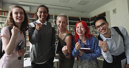 Group of happy students celebrating success posing for camera