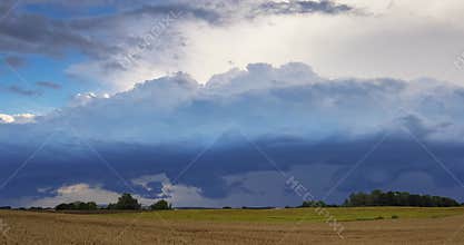 Storm clouds moving to the viewer. Dangerous storm supercell shelf cloud with layers.