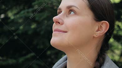 Close up portrait of attractive happy young relaxed woman enjoying nature breathing fresh air at calm spring or summer day