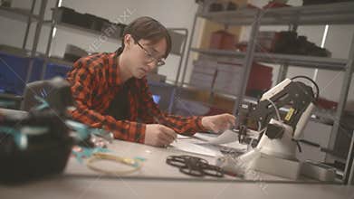 Male student learns basics of constructing sitting at table