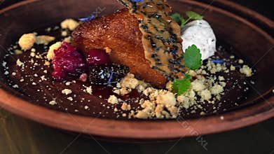 On a plate, honey cake is served with whipped cream and berries.